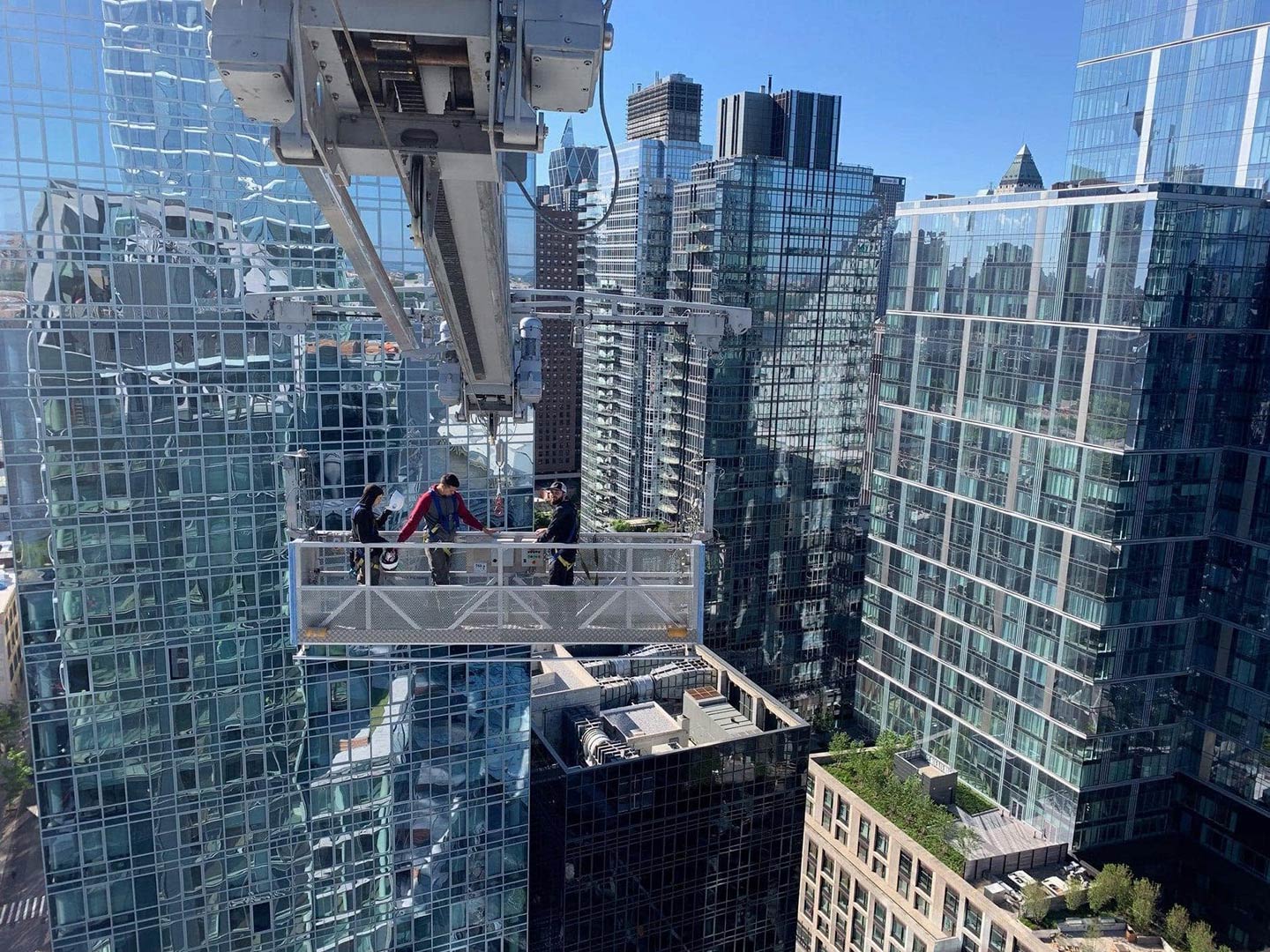 Skyway crew in a lift basket high above Manhattan glass towers