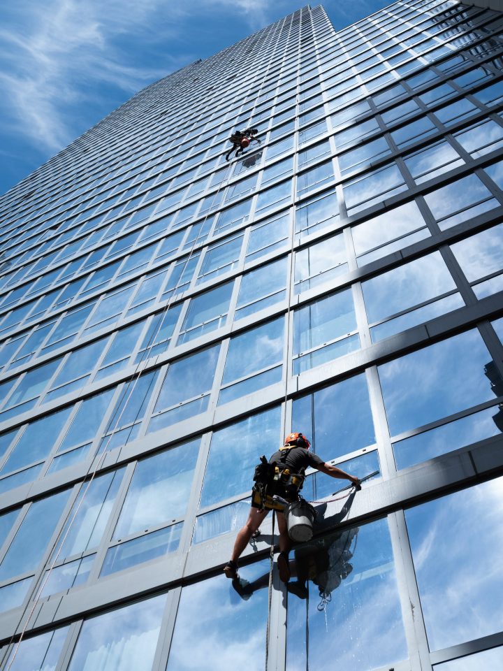 Rope access technicians cleaning the glass curtain wall of a New York high-rise