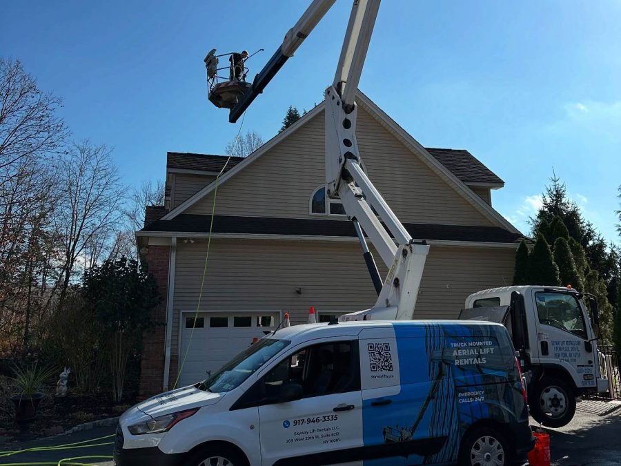 Skyway lift and van cleaning the windows of a family home