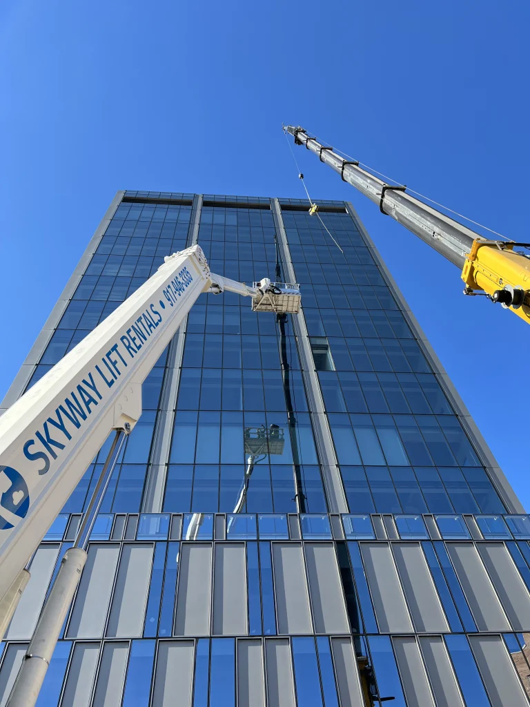 Skyway Lift Rentals boom reaching up a glass high-rise