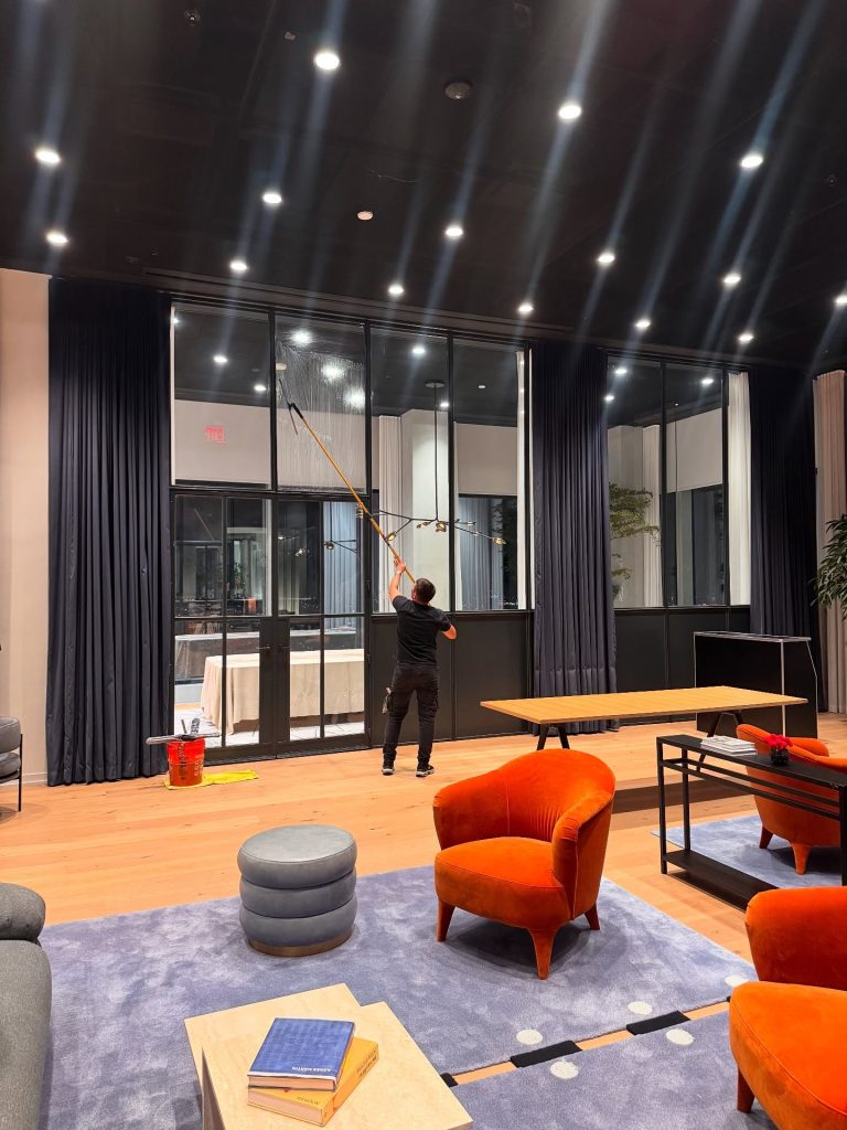 Skyway technician cleaning the interior glass of a modern office lobby