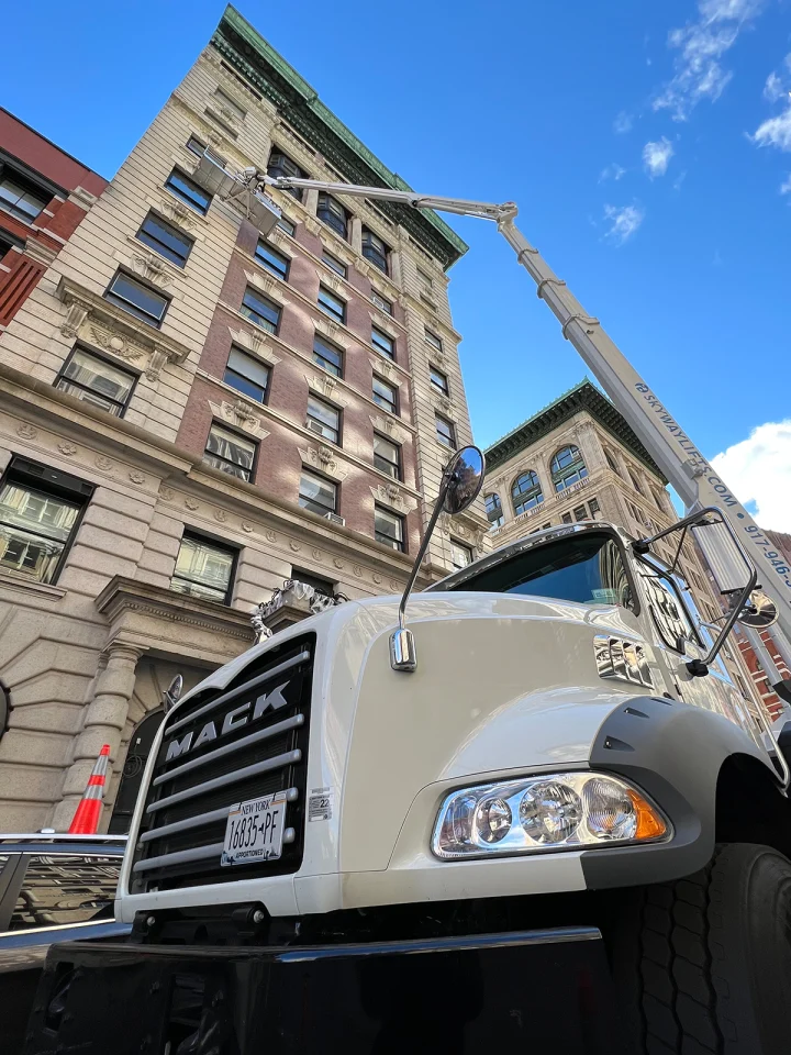 Skyway Lifts Mack truck with its boom extended up a historic Manhattan facade