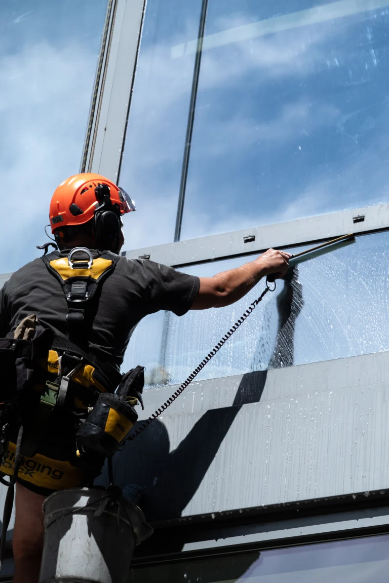 Close-up of a technician squeegeeing a large glass panel