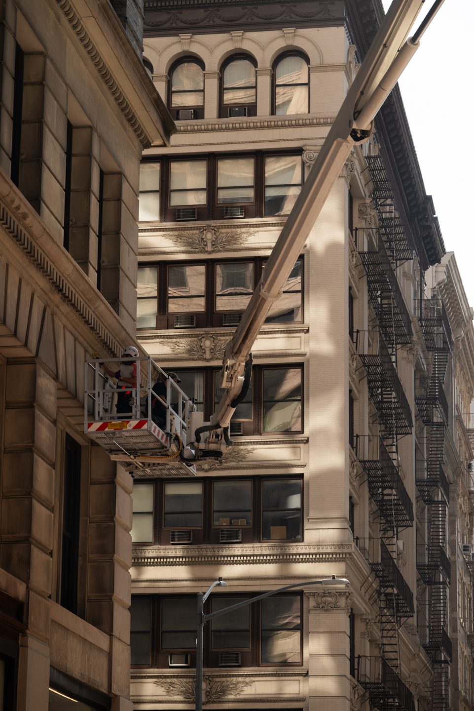Skyway lift basket beside the cornices and ledges of a classic stone building in New York