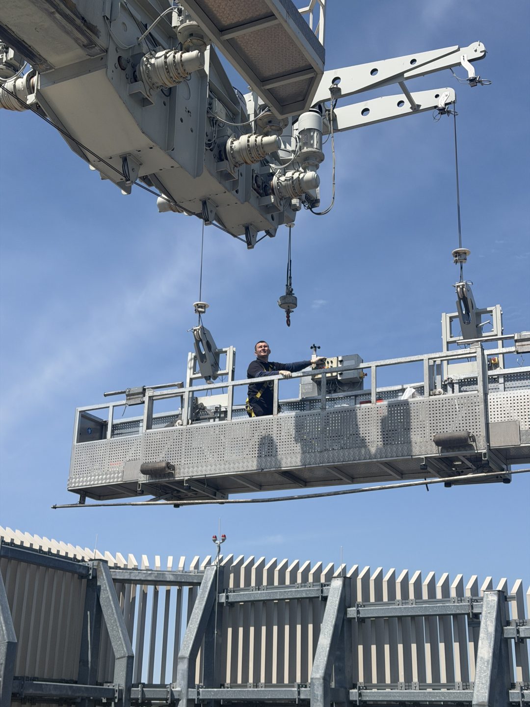 Skyway window cleaner on a suspended scaffold hanging from a high-rise roof