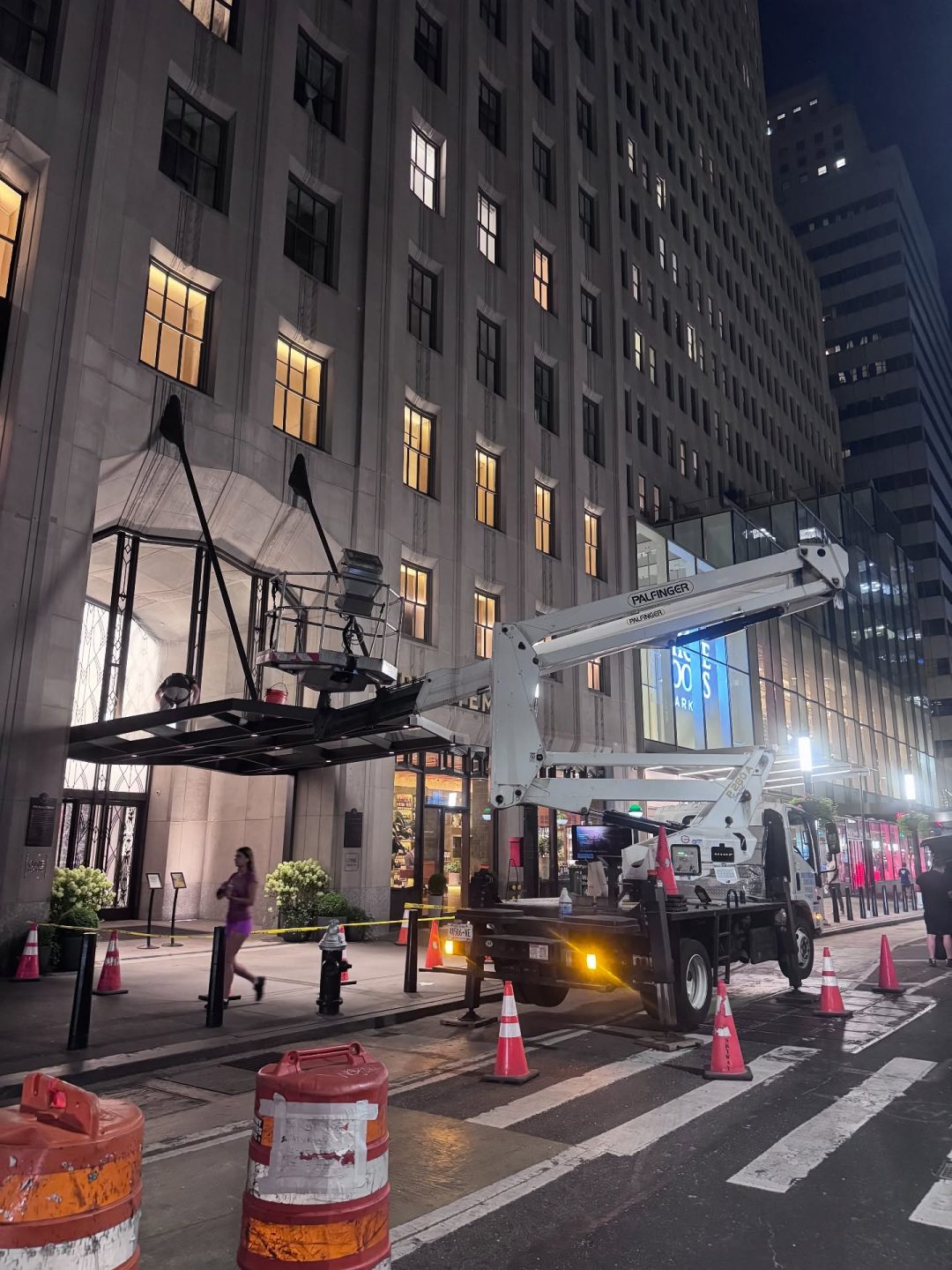 Skyway lift cleaning a building entrance canopy at night in Manhattan