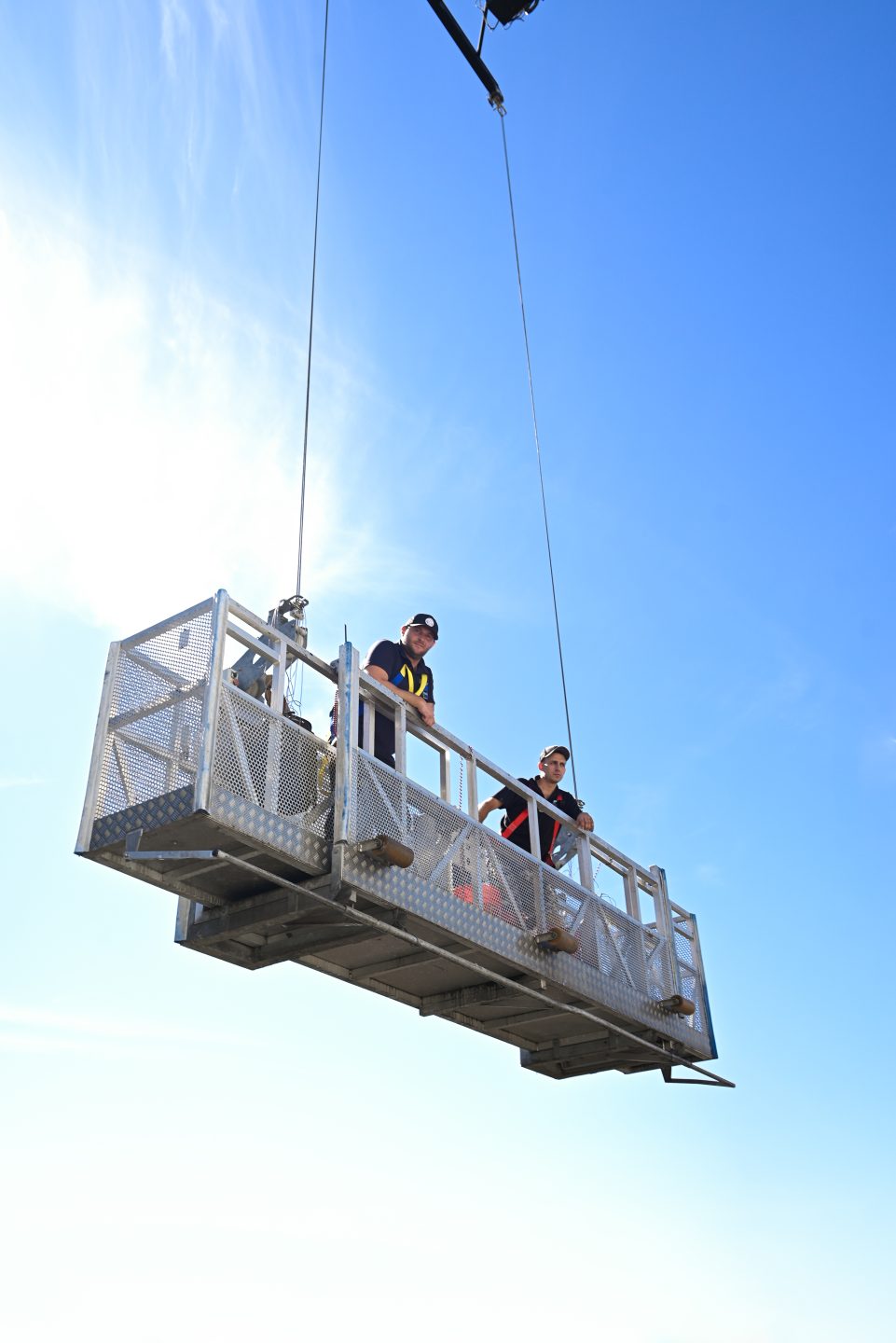 Skyway crew on a suspended platform working on a building facade